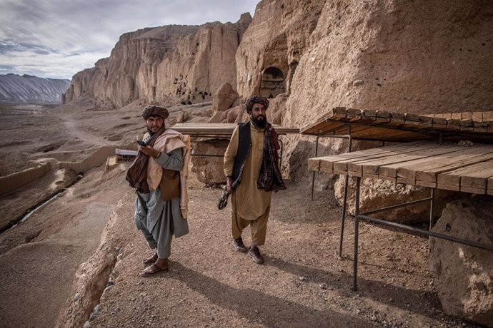 15 November 2022, Afghanistan, Bamyan: Two Taliban fighters patrol at the site where a monumental, 38 meters tall Buddha statue was carved into the side of a cliff in Bamyan. Two massive buddha statues with the smaller reaching 38 and the larger reachin