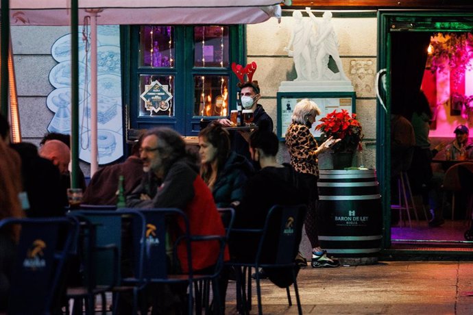 Archivo - Tres amigos toman el aperitivo en la plaza del 2 de mayo para celebrar la llegada de la Nochebuena, a 24 de diciembre de 2021, en Madrid (España). A pesar de las nuevas restricciones, como el uso de la mascarilla en exteriores, que entra en vi