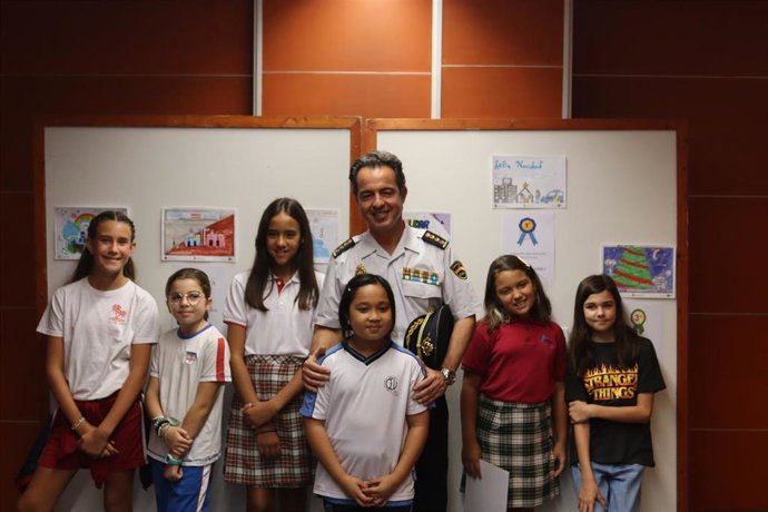 El jefe Superior de la Policía Nacional en Canarias, Jesús María Gómez Martín, con las seis ganadores del concurso de dibujo organizado por Policía Nacional y El Corte Inglés