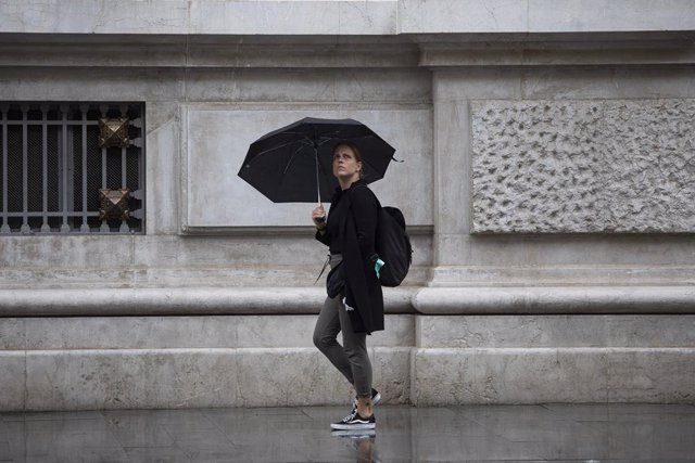 Archivo - Una mujer se protege de la lluvia bajo su paraguas. A 21 de octubre de 2022, en Sevilla (Andalucía, España). 