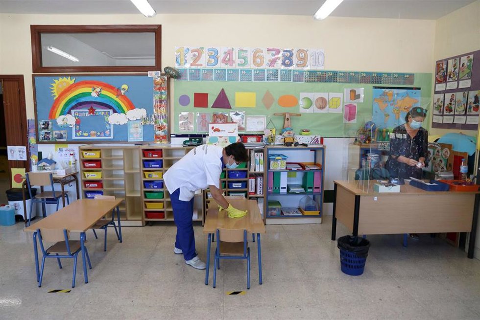 Archivo - Una limpiadora desinfecta un aula.