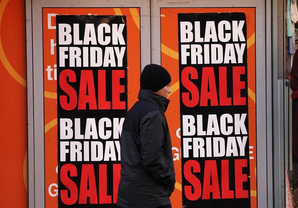 25 November 2022, Ireland, Dublin: Aman walks by signs for Black Friday sales. Photo: Brian Lawless/PA Wire/dpa