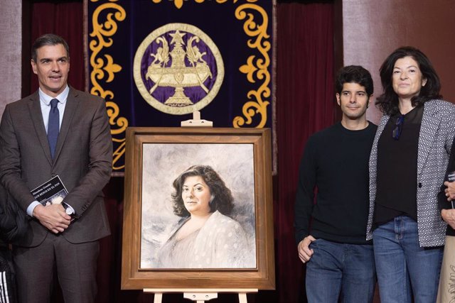 El presidente del Gobierno, Pedro Sánchez, el hijo de Almudena Grandes y su hermana, con un cuadro de la escritora, en el primer aniversario de su fallecimiento, en el Salón de actos del Ateneo, a 28 de noviembre de 2022, en Madrid (España). 