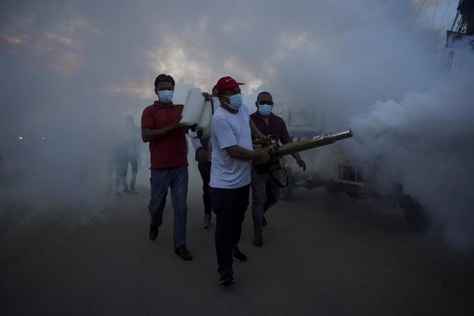 Archivo - Un trabajador fumiga durante una campaña contra la fiebre del dengue en Katmandú, Nepal