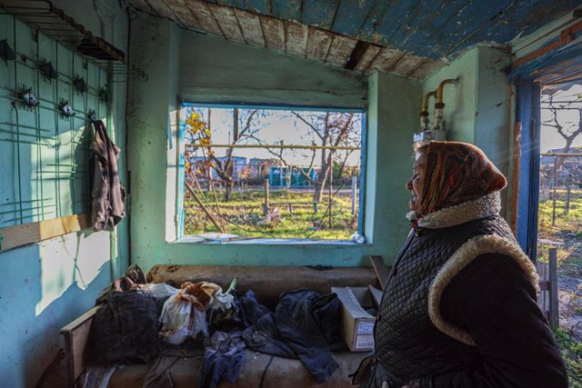 Anna, una mujer ucraniana de 67 años, reacciona mientras examina su casa dañada por los ataques de la artillería rusa en un pueblo de la región de Jersón, Ucrania.