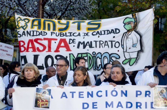 Varias personas con pancartas participan durante una concentración de sanitarios en el arranque de la segunda semana de huelga de médicos y pediatras de Atención Primaria, frente a la Consejería de Hacienda
