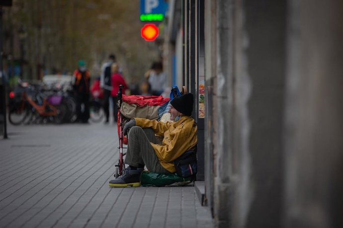 Archivo - Una persona sin techo permanece en el suelo de una calle 