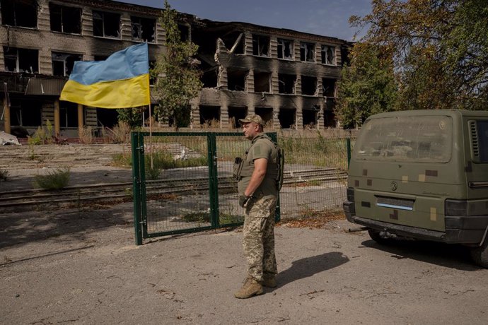 Archivo - September 3, 2022, Kharkiv, Ukraine: A Ukrainian soldier stands near the Ukraine flag outside of a destroyed building near Kharkiv, Ukraine on September 3, 2022. The Russia-Ukraine War continues with no end in sight.,Image: 719207430, License: