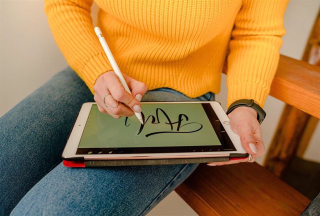 Una persona firma en una tableta
