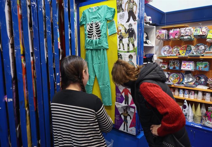 Archivo - Una mujer observa disfraces de Halloween 