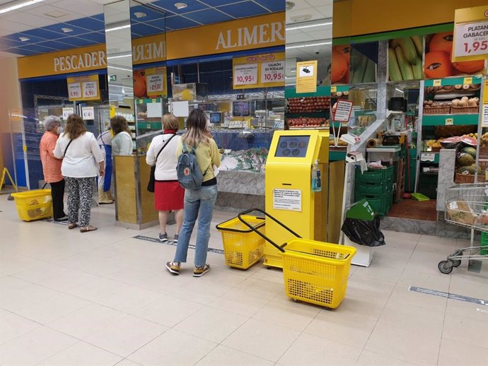 Archivo - Gente haciendo la compra en un supermercado