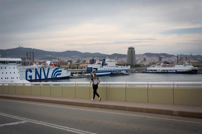 Archivo - Una chica corre frente a la terminal de cruceros del Puerto de Barcelona, visto desde el Puente de la Puerta de Europa, a 30 de mayo de 2022, en Barcelona, Cataluña (España). L