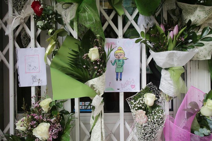 Un dibujo y varias flores colgadas en la tienda de alimentación donde trabajaba la mujer de 42 años muerta a cuchilladas en Lugo.