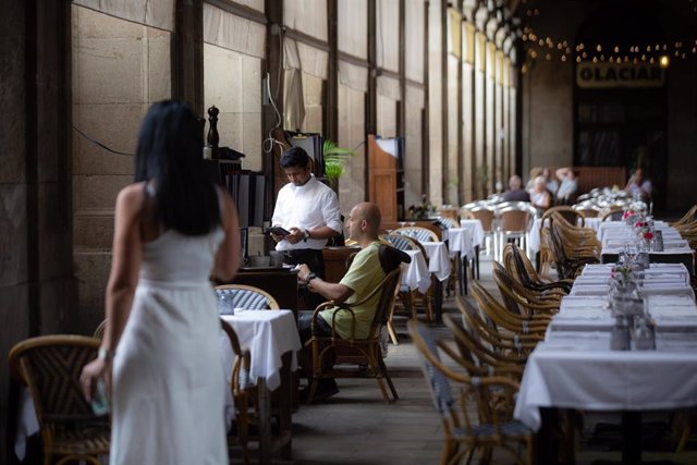 Archivo - Un camarero atiende a una mesa en la plaza Real de Barcelona, a 15 de junio de 2022, en Barcelona, Catalunya (España). Los empresarios del turismo y la hostelería han reiterado la ausencia de trabajadores en su sector. Situación que ha sido prov
