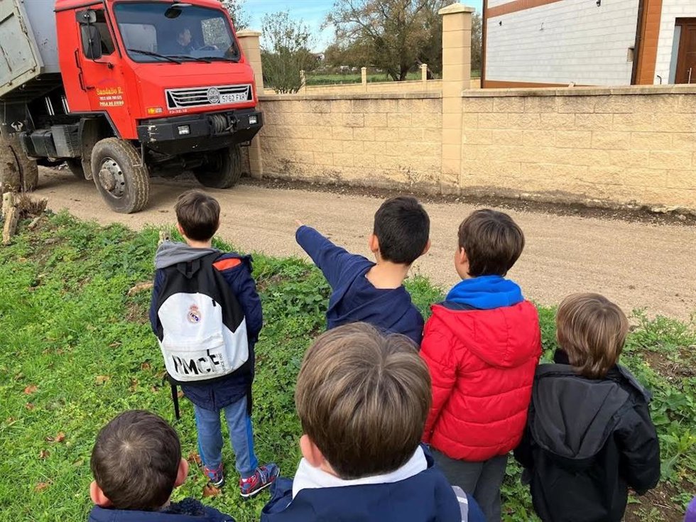 Un grupo de niños delante de un camión de obra