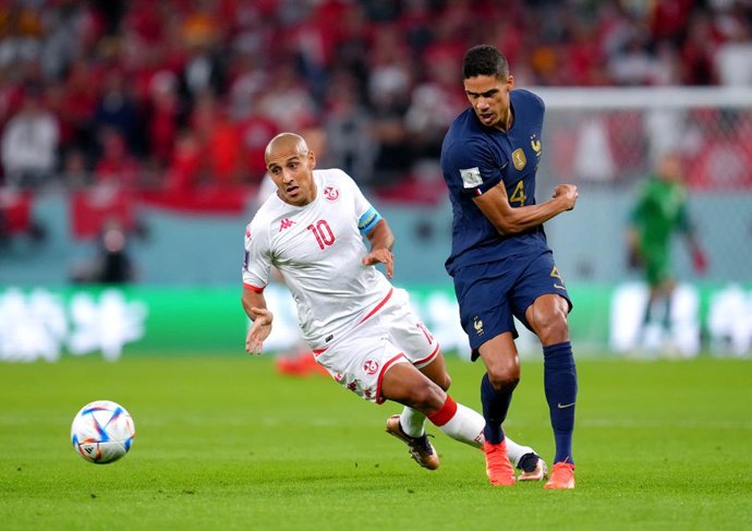 30 November 2022, Qatar, Al Rayyan: Tunisia's Wahbi Khazri (L) and France's Raphael Varane battle for the ball during the FIFA World Cup Group D soccer match between Tunisia and France at the Education City Stadium. Photo: Nick Potts/PA Wire/dpa