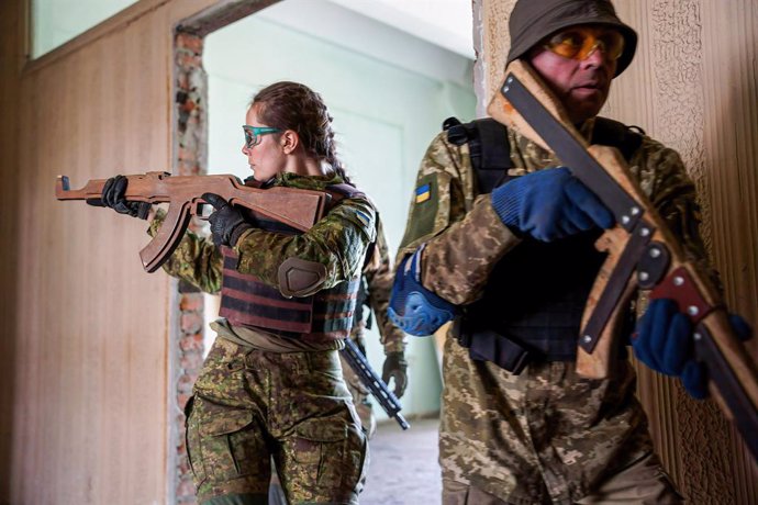 Archivo - May 24, 2022, Lviv, Ukraine: Two soldiers carrying simulation firearms conduct a room clearance exercise in a territorial defence training compound. Ukrainian military officers train themselves during the territorial defence exercise in Lviv. 