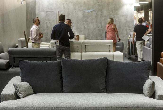 Archivo - Varias personas viendo muebles