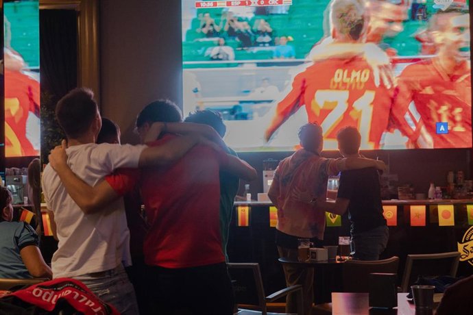 Aficionados que siguen en pantallas gigantes en un sport bar el primer partido de la selección española en el Mundial de Qatar  celebran el primer gol de la selección obra del jugador Dani Olmo a 23 de noviembre.