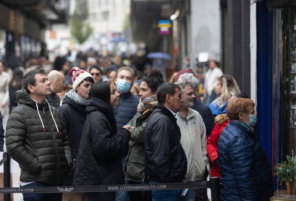 Varias personas en las inmediaciones de la administración de loterías Doña Manolita, a 14 de noviembre de 2022, en Madrid (España). Doña Manolita es la administración que más factura en ventas de boletos de lotería de todo el país. A lo largo de su hist