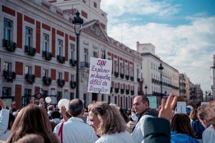 Una persona con un cartel que reza 'Sin explorar ni auscultar, difícil de diagnosticar' protesta frente a la sede del Gobierno regional durante una manifestación de médicos y pediatras