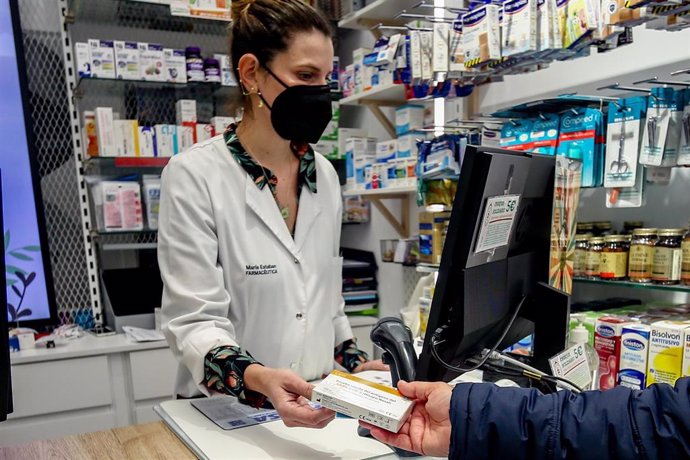 Archivo - La farmacéutica de la Farmacia Lavapiés, situada en la esquina de las calles Sombrerete y Lavapiés, recoge un test de antígenos dentro de una campaña puesta en marcha para donarlos a excluidos sociales, a 28 de diciembre de 2021, en Madrid (Es