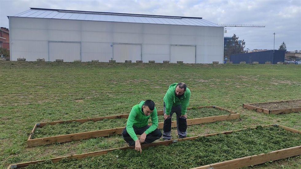 Zona de cultivo con el centro de día al fondo.