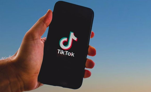 Archivo - Un usuario de TikTok sostiene un teléfono móvil con la aplicación abierta.