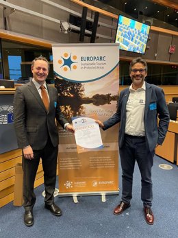 Pérez y García muestran el certificado de renovación de la Carta Europea de Turismo Sostenible, que han recogido en Bruselas.