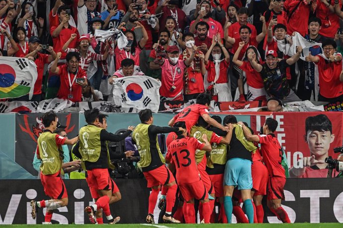 02 December 2022, Qatar, Al-Rayyan: South Korea's Hwang Heechan (obscured) celebrates with his teammates after scoring his side's second goal during the FIFA World Cup Qatar 2022 Group H soccer match between South Korea and Portugal at the Education Cit