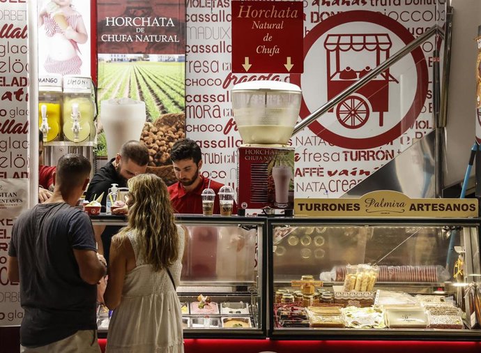 Archivo - Dos personas piden un helado en Valncia