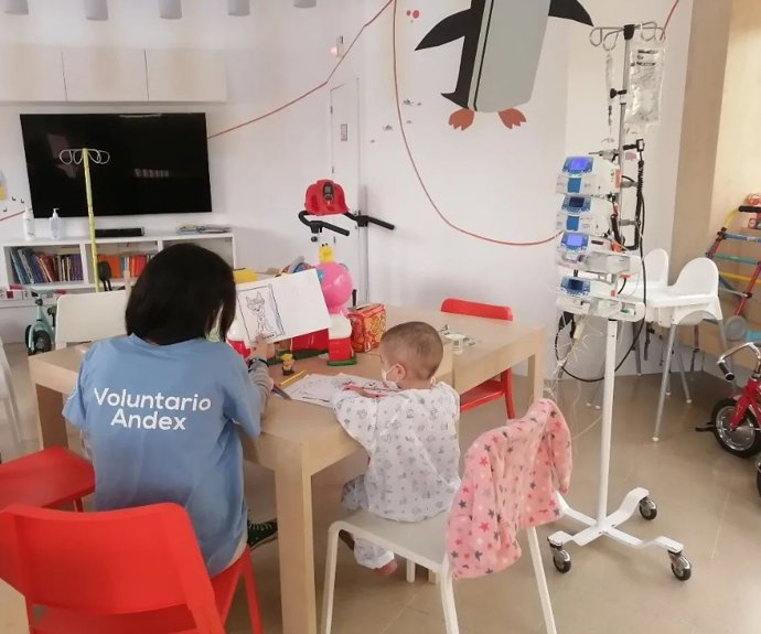 Voluntaria atendiendo a un menor hospitalizado en el Virgen del Rocío de Sevilla.