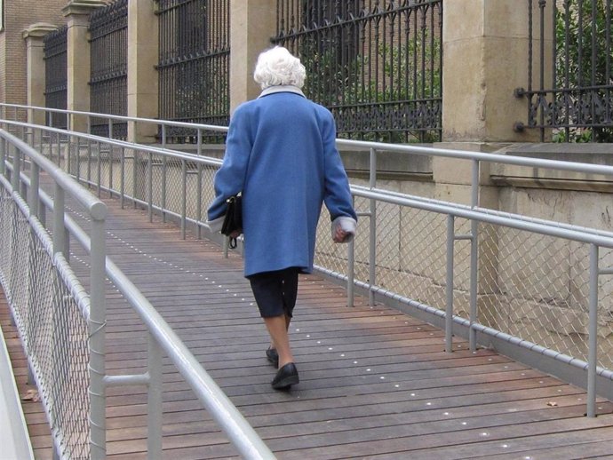 Archivo - Una mujer mayor camina por una rampa para superar el desnivel de acceso a un edificio