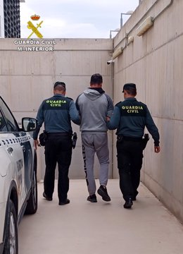 El detenido, custodiado por dos agentes de la Guardia Civil