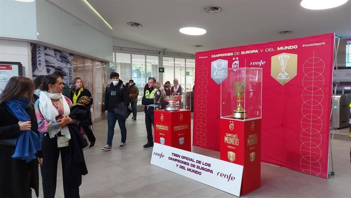 Usuarios del Cercanías en San Bernardo contemplan las copas del Eurobasket y del Mundial de baloncesto.