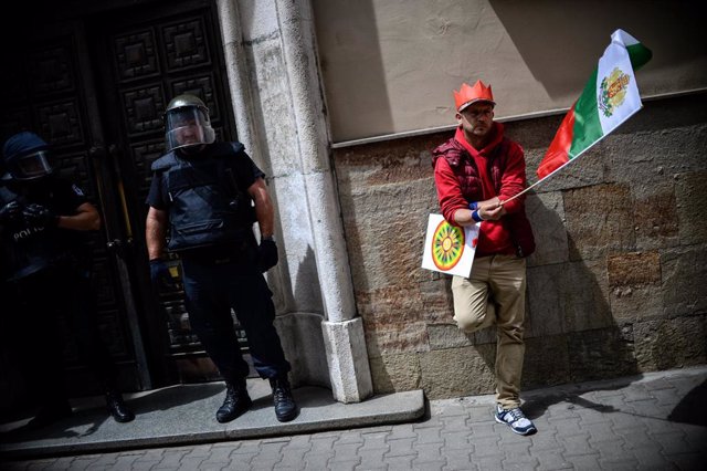 Archivo - Un hombre con una bandera búlgara frente a un policía con equipo antidisturbios en Bulgaria