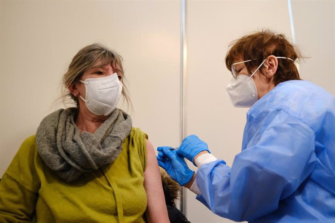 Archivo - Martina Zongos (izquierda) recibe una dosis de la vacuna de Novavax contra la COVID-19 en una cabina de vacunación de un centro de vacunación. En Bremen (Alemania), a 1 de marzo de 2022.