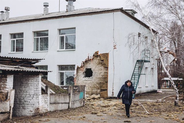 Archivo - Una mujer camina frente a la guardería donde hoy ha impactado un proyectil, a 17 de febrero de 2022, en Stanitsa Luganska, Oblast de Lugansk (Ucrania).