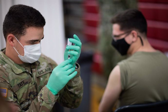Un soldado de EEUU prepara una dosis de la vacuna para suministrar a otro soldado.