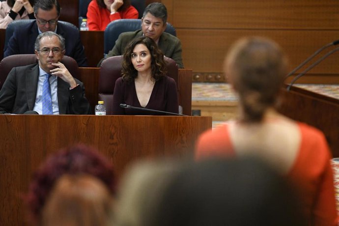 La presidenta de la Comunidad de Madrid, Isabel Díaz Ayuso (c), atiende a la portavoz de Más Madrid, Mónica García, durante su intervención una sesión plenaria en la Asamblea de Madrid, a 1 de diciembre de 2022, en Madrid (España). El Pleno de hoy de la