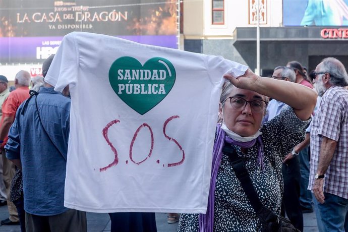 Archivo - Una mujer muestra una camiseta que reza 'Sanida Pública SOS' mientras se manifiesta por la Sanidad Pública