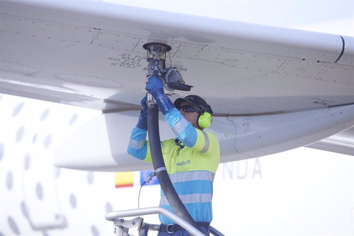 Un operario realiza la maniobra para recargar un avión.