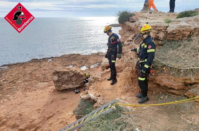 Efectivos de bomberos rescatan a un hombre tras caer desde una altura de unos seis o siete metros en una zona de rocas en la cala Redona, en el municipio de Torrevieja (Alicante)
