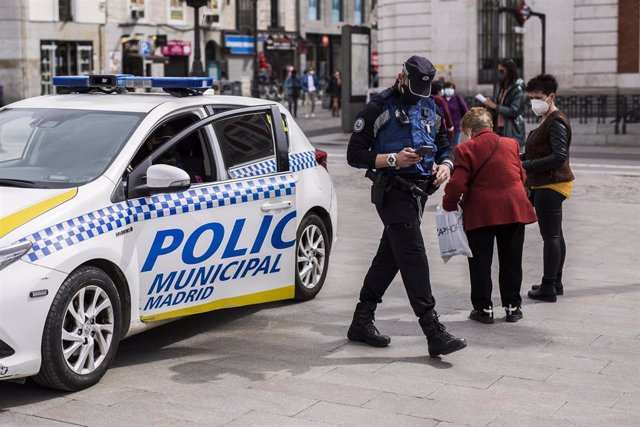 Archivo - Un agente de Policía Municipal de Madrid y un vehículo de la misma, en la Puerta del Sol