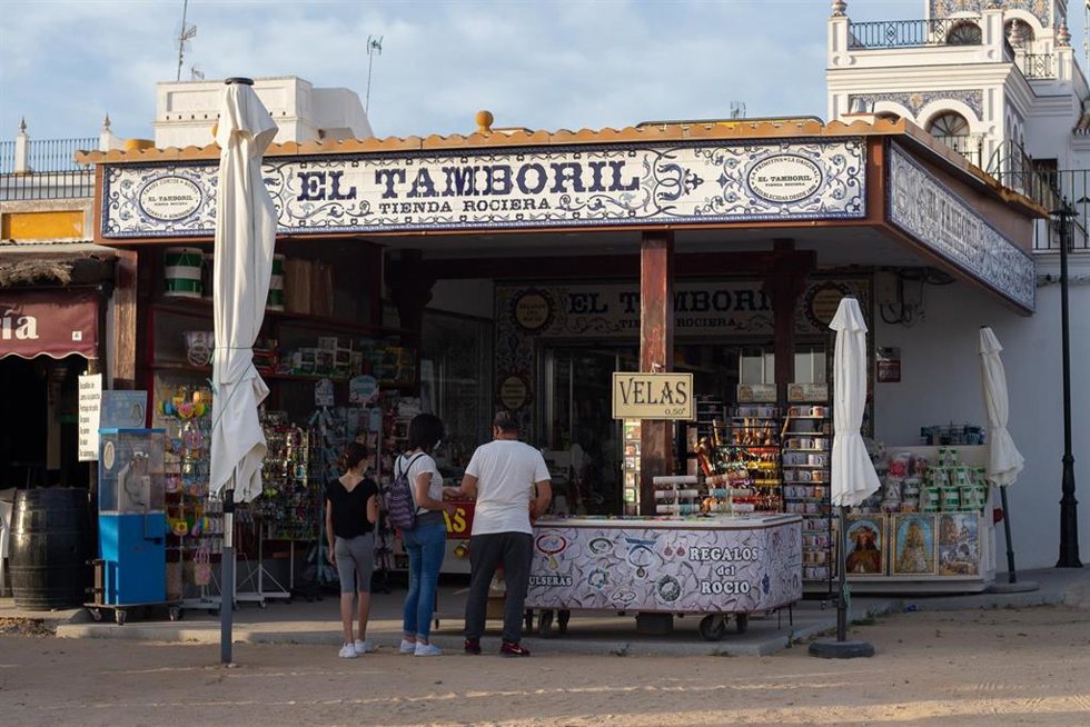 Archivo - Detalle de una familia comprando velas en una tienda de souvenir rociero durante el fin de semana.