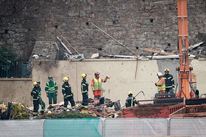 11 December 2022, United Kingdom, Jersey: Specialist rescue teams work at the scene of an explosion and fire at a block of flats in St Helier. At least three people have died and a dozen are missing following the blast. Photo: Aaron Chown/PA Wire/dpa