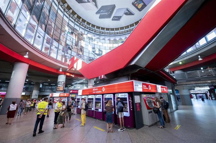 Archivo - Varias personas en las taquillas de venta automática de billetes en la estación de tren de Atocha
