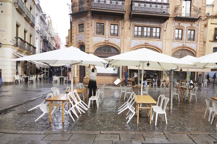 Detalle de los veladores vacíos en la terraza de un bar en el puente del mes de diciembre en Sevilla.