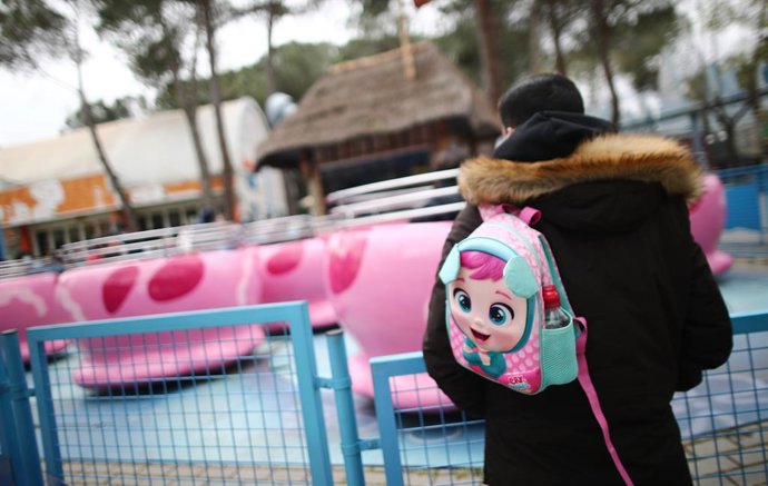 Archivo - Un hombre con una mochila en las inmediaciones de una atracción infantil del Parque de Atracciones durante el Día del Padre, en Madrid (España), a 19 de marzo de 2021. El Parque de Atracciones reabrió el pasado 6 de marzo con un aforo limitado