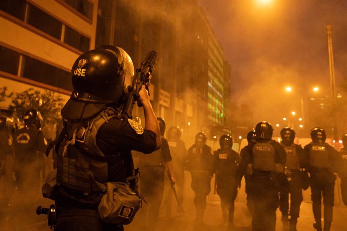 11 December 2022, Peru, Lima: A police officer fires tear gas at demonstrators during a protest. After the president's impeachment in Peru, there were protests in several cities, including the capital Lima. Photo: Lucas Aguayo Araos/dpa